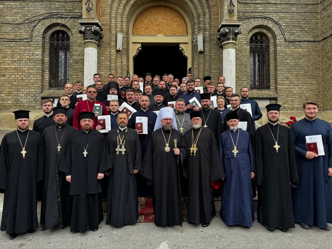 Групова фотографія перед входом до цегляного храму